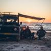 Twee kampeerders genieten van de zonsondergang op het strand bij Nørre Lyngby in Denemarken